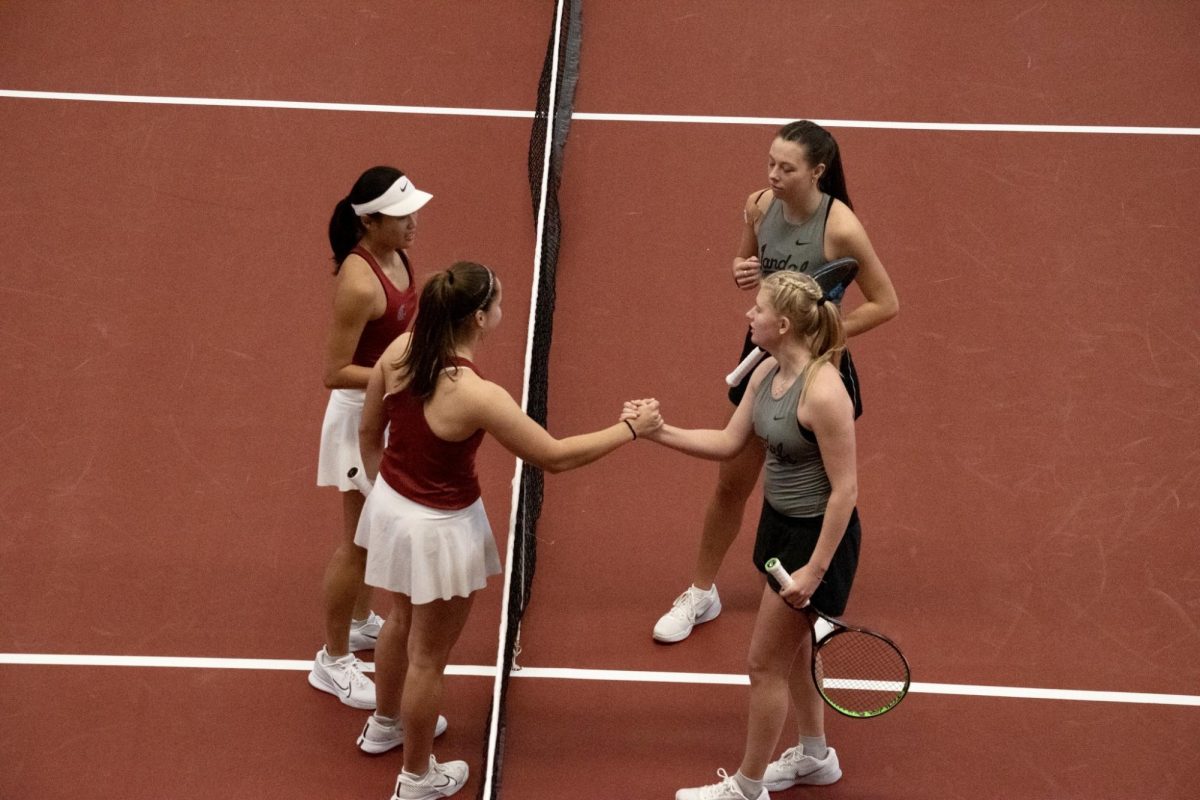 Eva Alvarez Sande and Elyse Tse high-five their doubles opposition after their set, Jan. 21, in Pullman, Wash. 