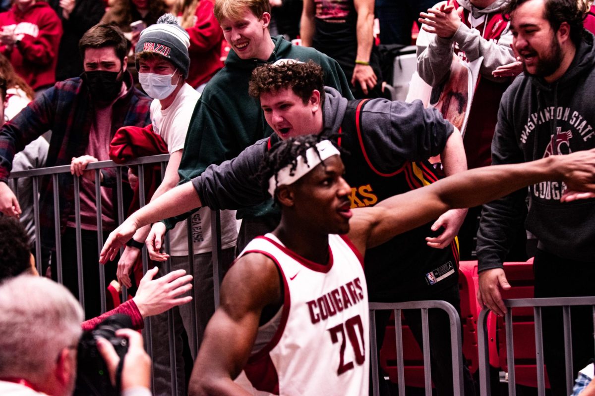 WSU students, including Matti TennEy high five Cougar players, including Rueben Chinyelu after WSU mens basketballs 78-69 win over Colorado, Jan. 27 in Pullman, Wash. 
