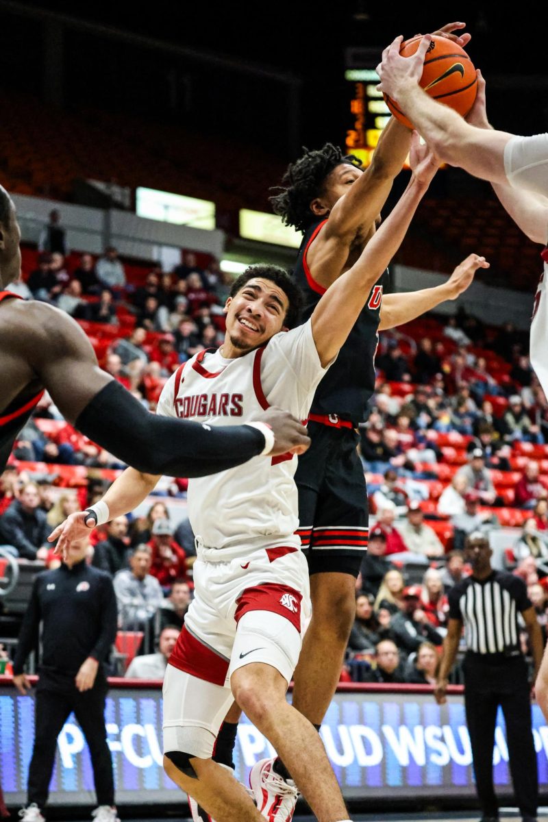 Guard Myles Rice reaches for the rebound amidst Utah defenders in an NCAA mens basketball game, Jan. 24, 2024, in Pullman, Wash. 