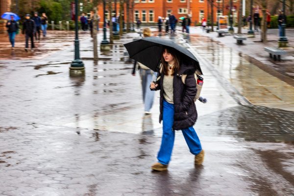 A WSU student holds an umbrella to block the rain while walking between classes, Feb. 12, in Pullman, Wash. 