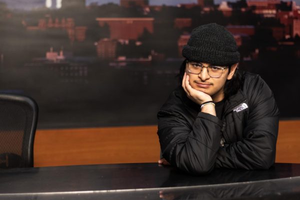 Cristian Gonzalez poses at the anchor desk of CougZone while preparing to direct an episode, Feb. 12, in Pullman, Wash.