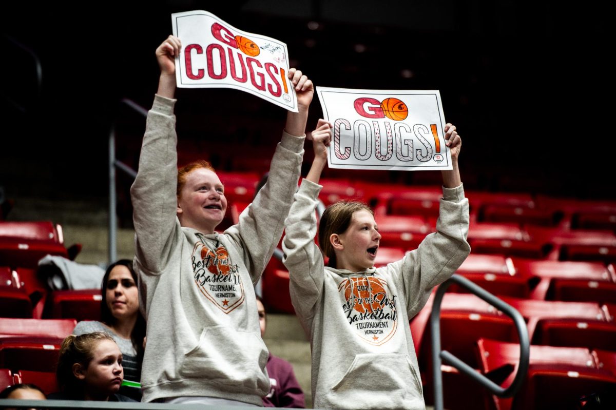 Two fans hold up Go Cougs signs during WSU and Stanfords game Sunday afternoon, Feb. 11, in Pullman, Wash.