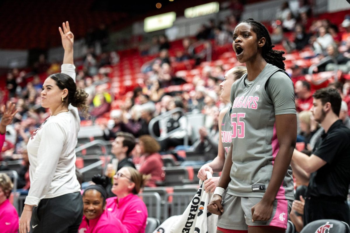 Bella Murekatete yells in celebration as Charlisse Leger-Walker holds up three fingers after a bucket, Feb. 11, in Pullman, Wash.