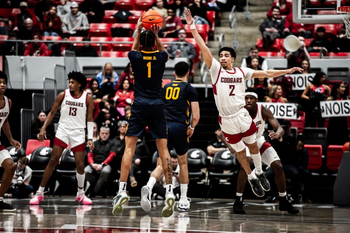 Myles Rice stretches out to defend a Cal three-pointer, Feb. 15, in Pullman, Wash.