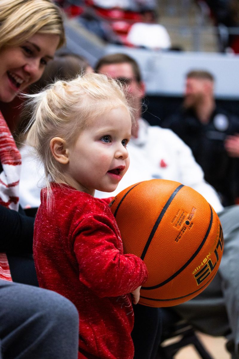 A young fan holds the basketball between plays during an NCAA mens basketball game against Cal, Feb. 15, 2024, in Pullman, Wash. 