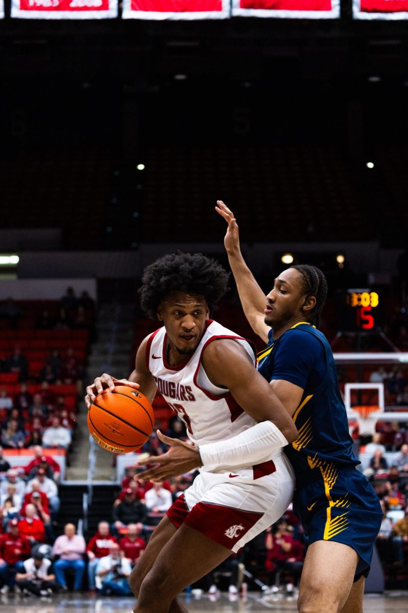 Forward Isaac Jones tries to drive to the hoop past a Cal defender in an NCAA mens basketball game, Feb. 15, 2024, in Pullman, Wash. 