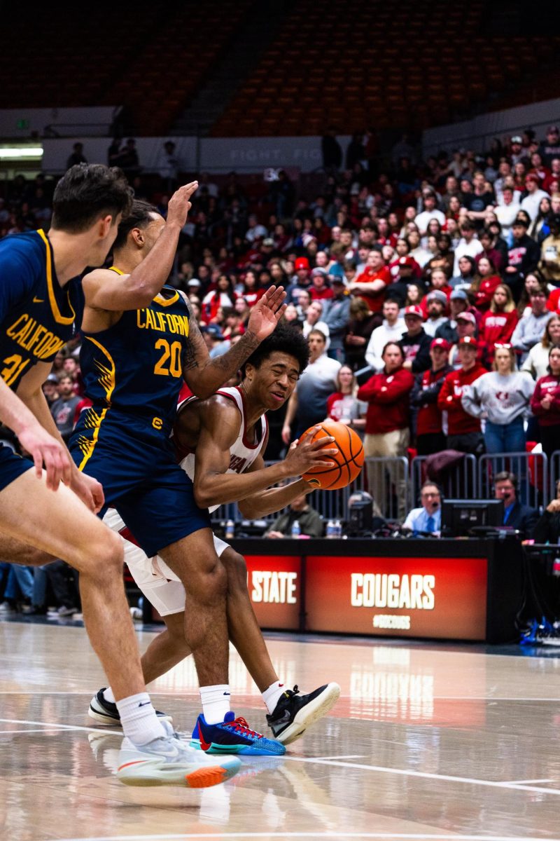 Forward Jaylen Wells tries to drive past Cal defenders during an NCAA mens basketball game, Feb. 15, 2024, in Pullman, Wash. 