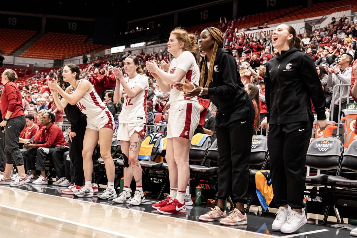 The WSU bench celebrates as the Cougs take a lead at the end of the third quarter, March 29, in Pullman, Wash. 