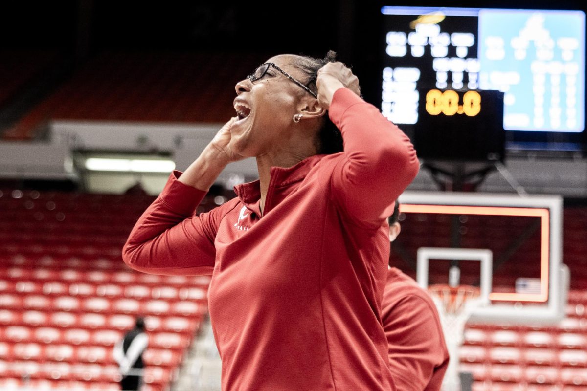WSU assistant coach Camille Williams celebrates toward the crowd after the Cougs win, March 29, in Pullman, Wash. 