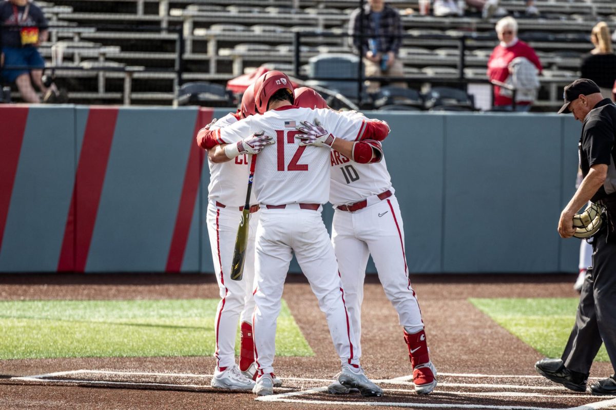 A trio of Cougs embrace at home plate after Griffen Sotomayor's home run, March 20 2024, in Pullman, Wash.