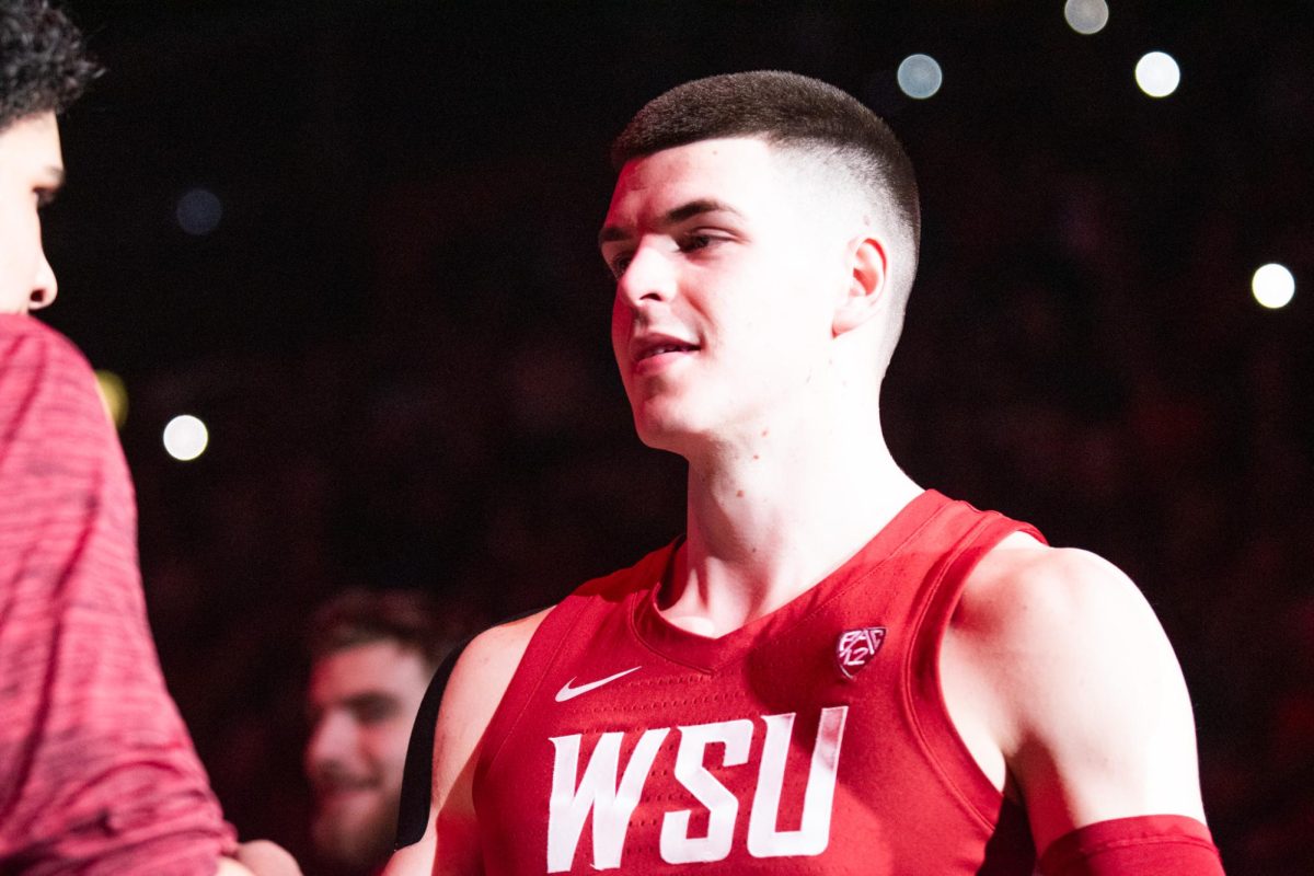 WSU senior forward Andrej Jakimovski greets freshman Spencer Mahoney during starting lineup introductions prior to an NCAA basketball game between WSU mens basketball and UW, March 7 in Pullman, Wash.