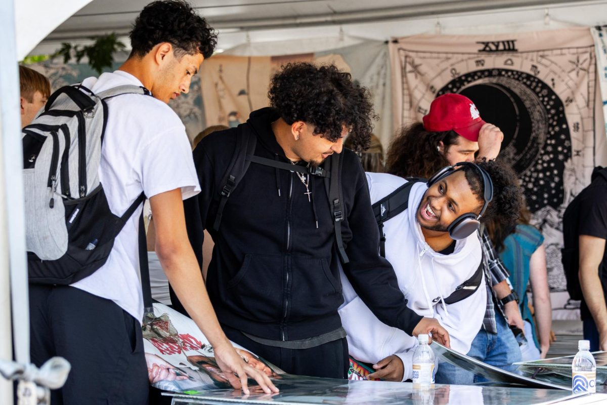 Two students smile as they look through posters for sale on the first day of class, Aug. 19, in Pullman, Wash. 