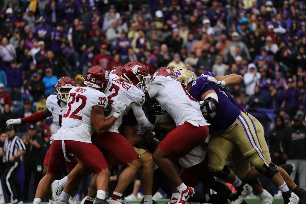 WSU defense pushes back against Washington offensive line in 2024 Apple Cup.