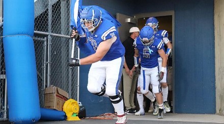 Pullman OL James Darling runs onto the field, raising the school flag