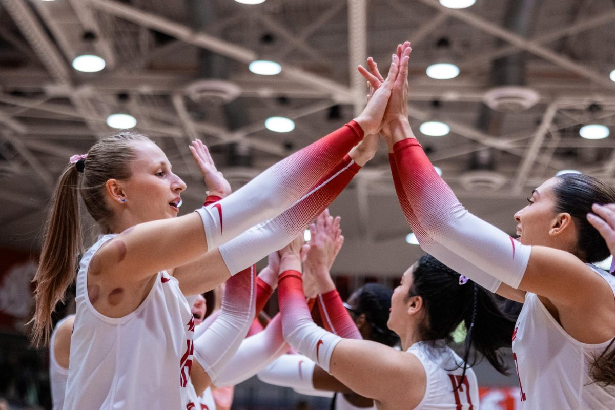 Weronika Wojdyla (L) gives teammates high-fives as the team runs out before their match against Portland, Oct. 3, in Pullman, Wash. 