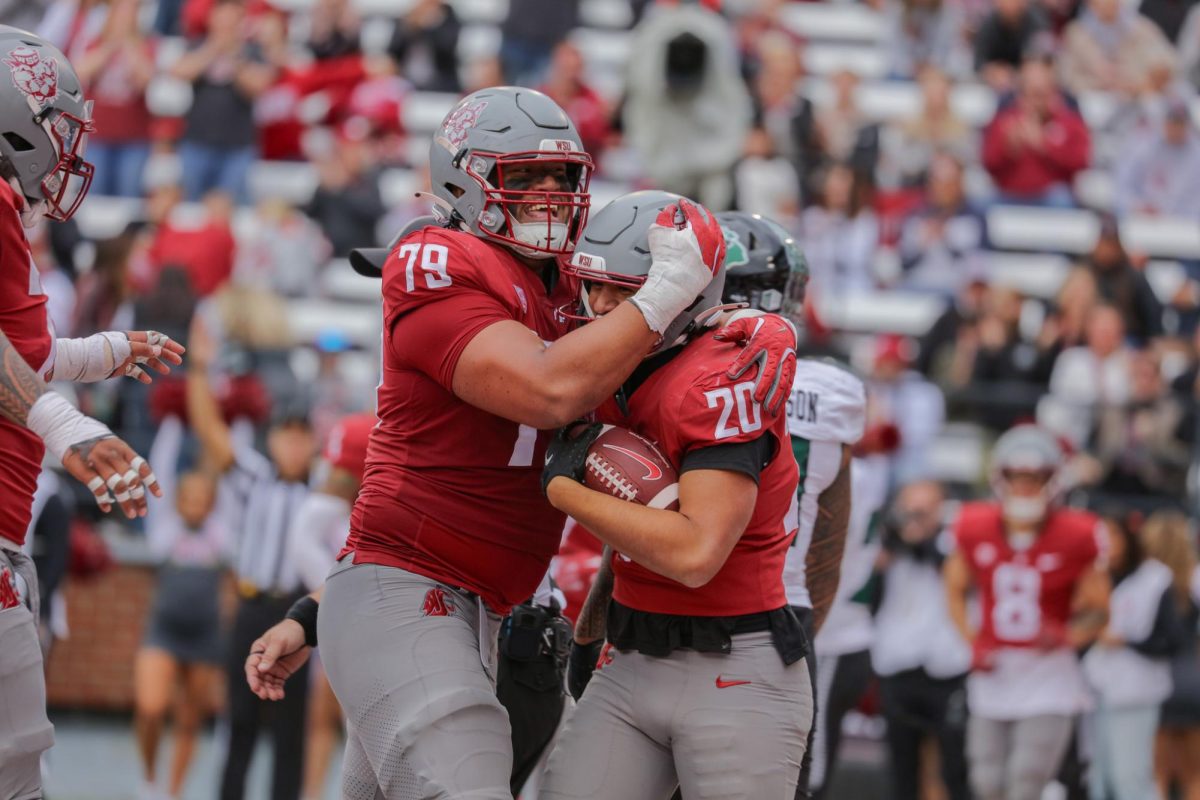 Fa'alili Fa'amoe (79) embraces Leo Pulalasi (20) after a big play against Hawaii on Oct. 19 at Gesa field in Pullman, WA. 