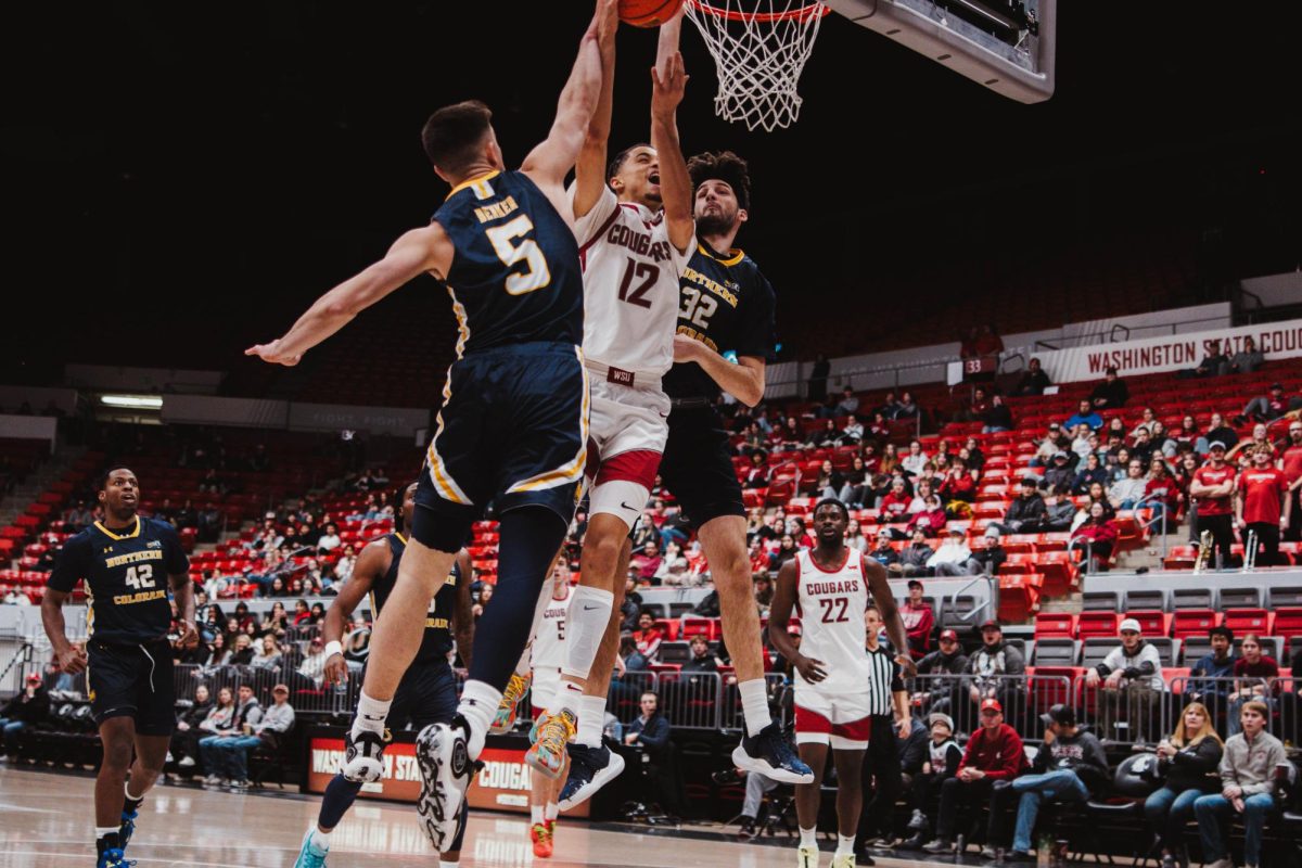 Isaiah Watts fights through two defenders to make a play at the rim, Nov. 18, in Pullman, Wash.