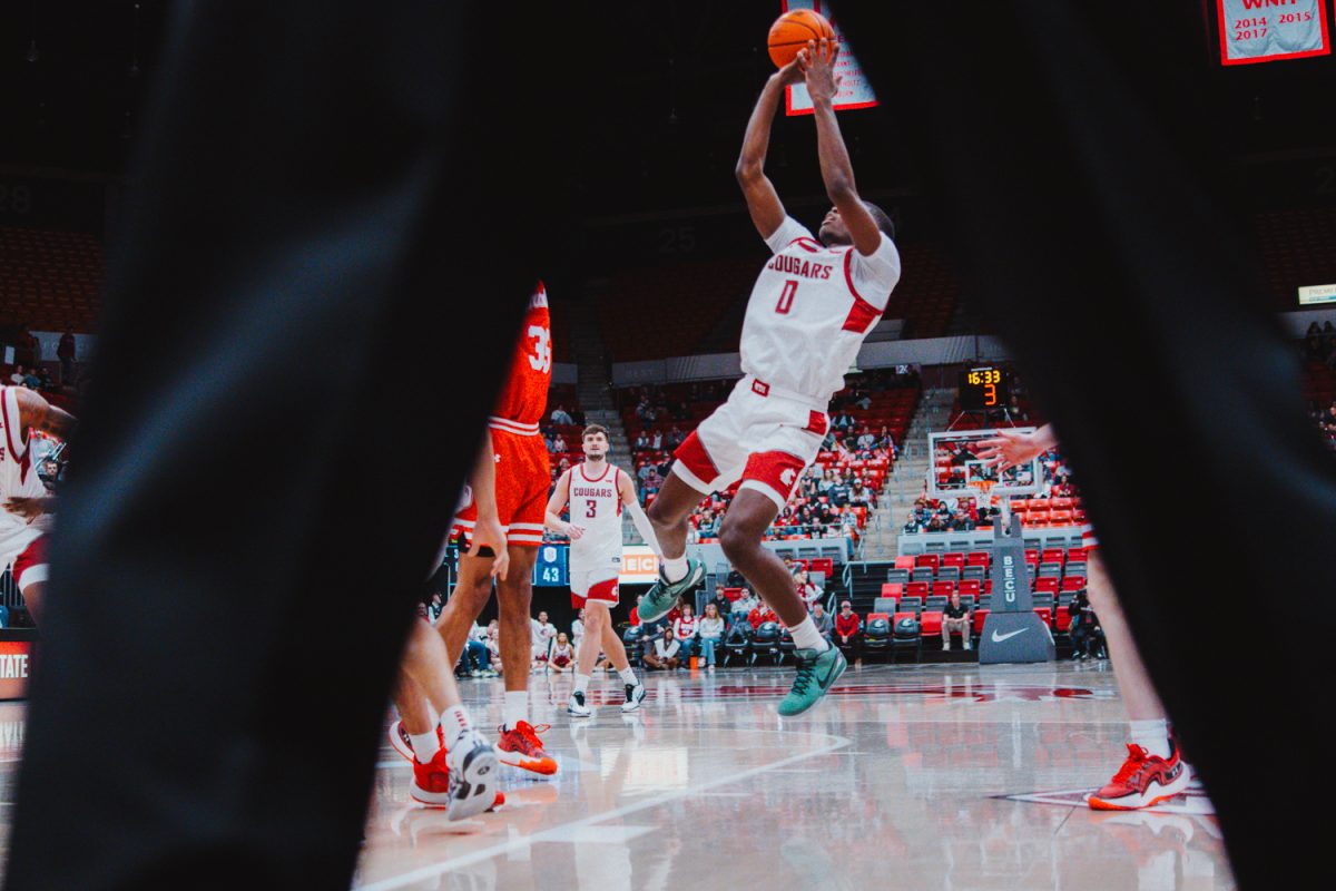 Cedric Coward fades at the elbow for a shot attempt, framed through the refs legs, Nov. 9, in Pullman, Wash. 