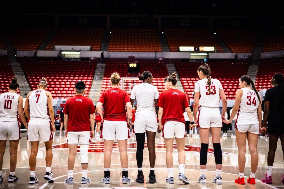 WSU WBB team holding hands during the national anthem.