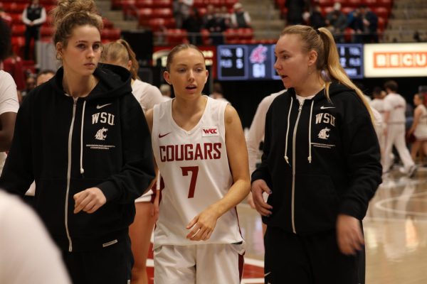 Guard Alice Dart talks with teammates Keandra Koorits and Charlotte Abraham (right) during the Cougs' matchup with Gonzaga on Jan. 11 in Pullman, Wash.