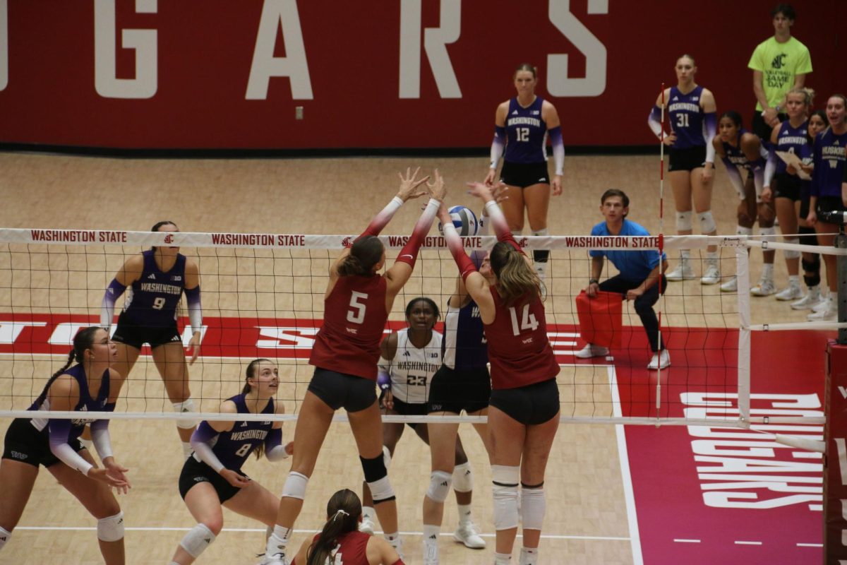Camryn Lingenbrink and Kate Hayhurst block a contested ball at the net against UW on Sept. 17.