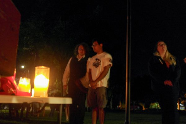 Two students stand silently and pay their respects to Charlie Kirk at his vigil on Sept.  13, 2025 at Reaney Park.