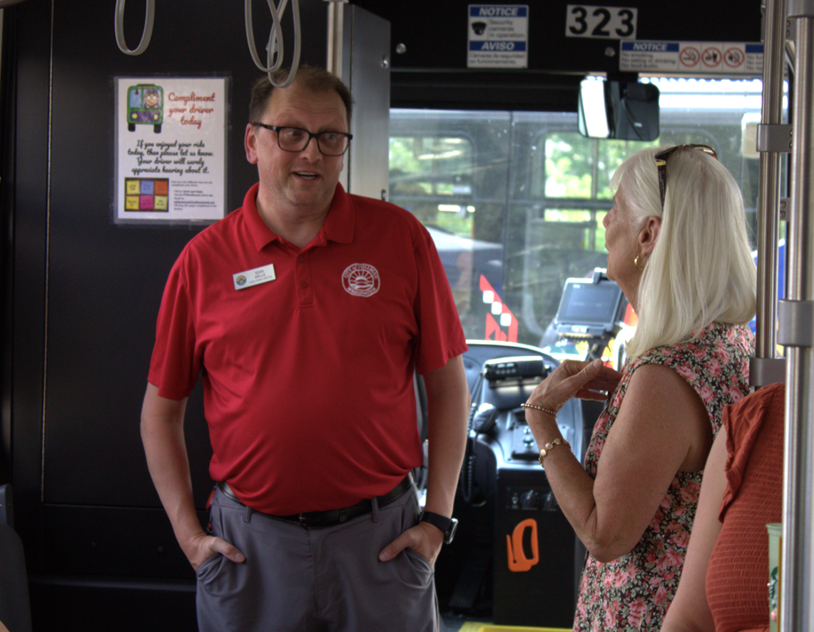 Public Works Director Sean Wells speaks with Downtown Pullman Association Executive Director Bobbie Ryder inside one of the new electric buses,