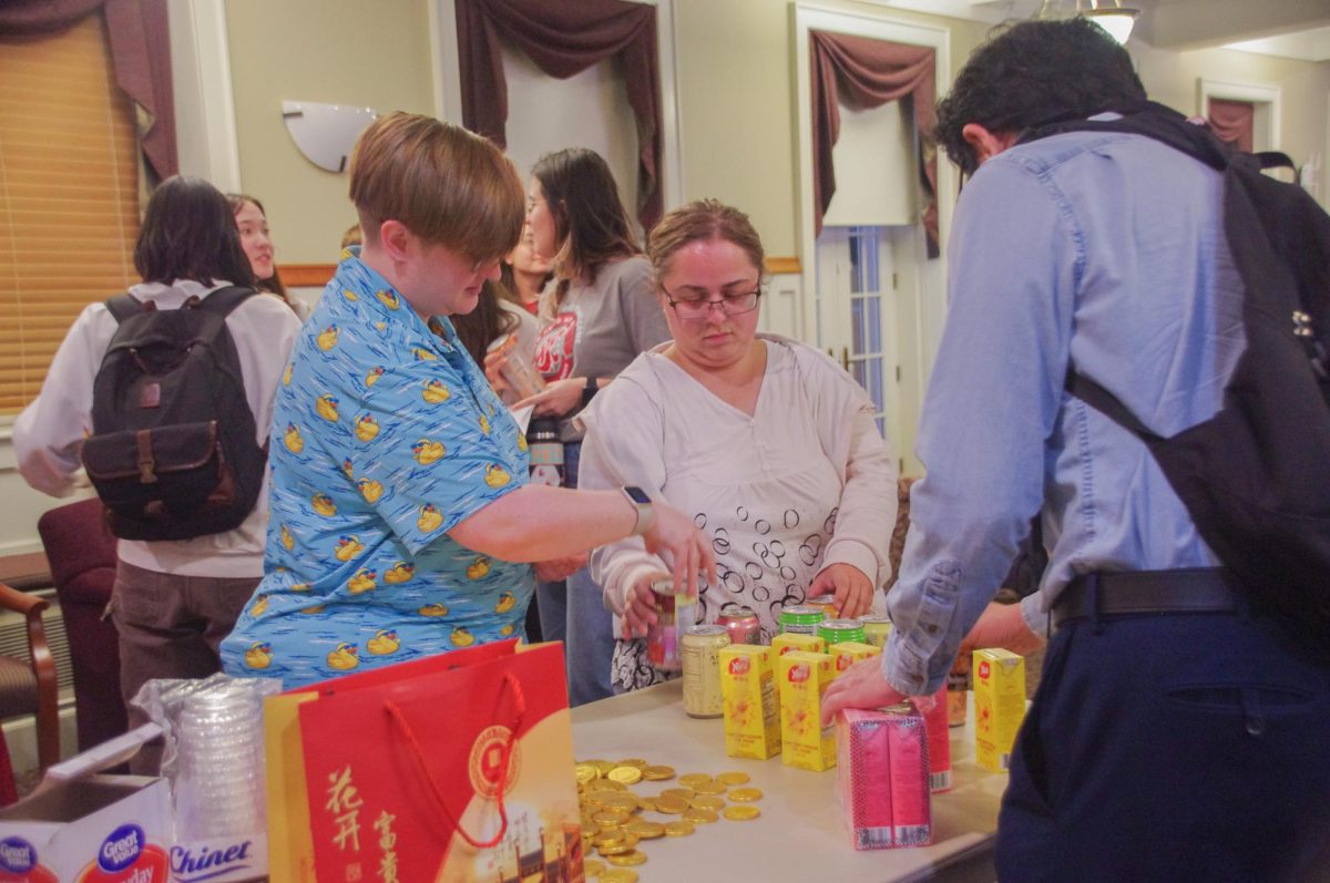 Chinese language students and WSU Professor Weiguo Cao choosing snacks from table before Mid-Autumn festival event begins, Oct. 6