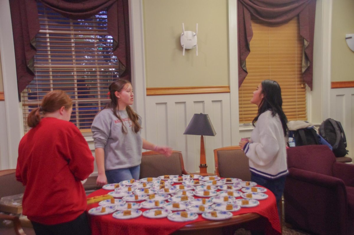 Chinese language students talking while setting and dishing up mooncake samples from the Mid-Autumn festival event, Oct. 6