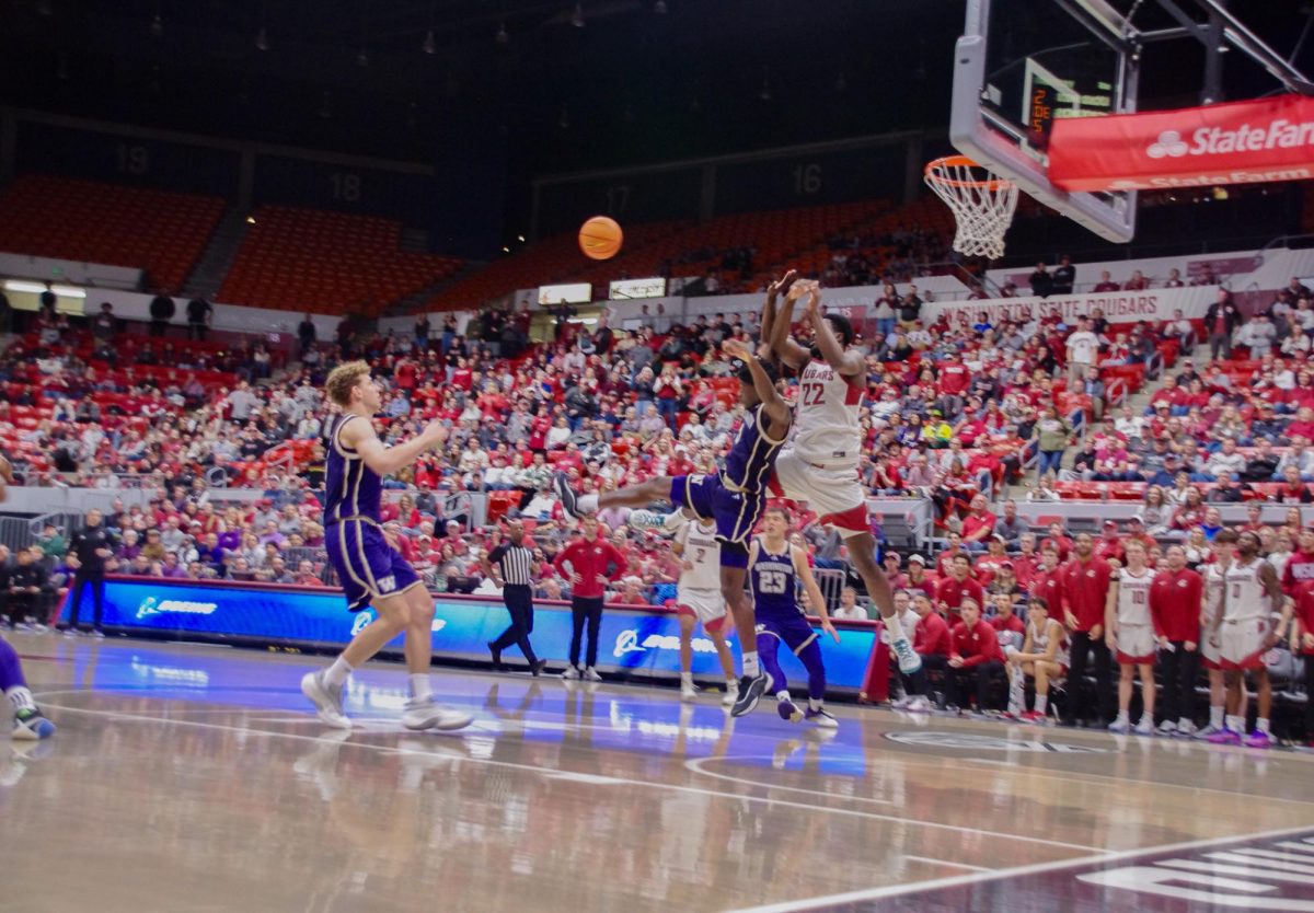 WSU Forward ND Okafor jumps to catch ball behind UW Guard Wesley Yates III, Nov. 14, 2025