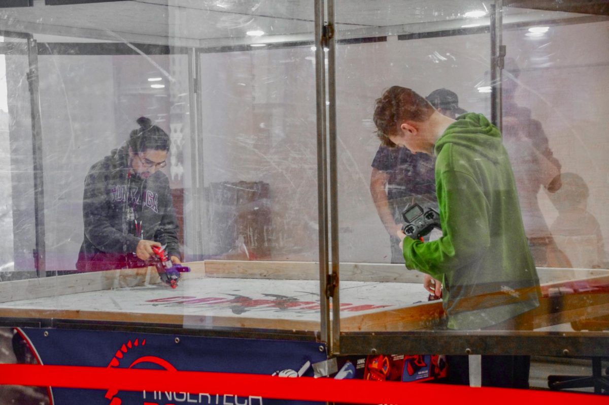Bot-fighting opponents unpinning their robots to prepare them to fight at Crimson Bot-Brawl, Nov. 15, 2025