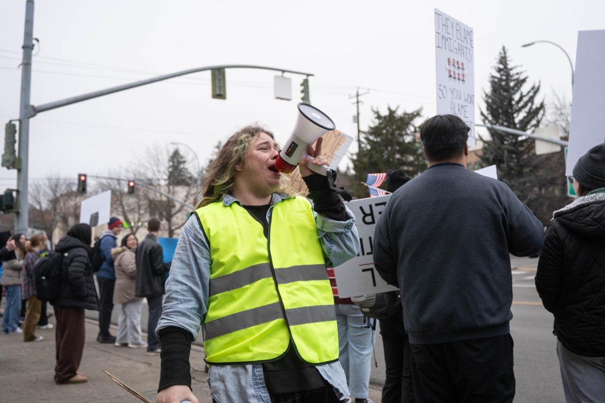 Protesters chant as cars pass by Cougar Plaza in downtown Pullman on Tuesday, Jan 20. 