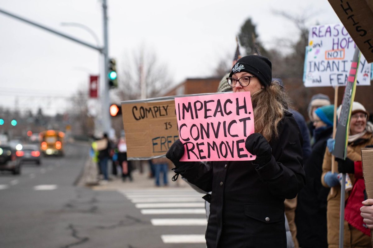 Anti-ICE protesters wave signs as cars pass by Cougar Plaza in downtown Pullman on Tuesday, Jan 20. 