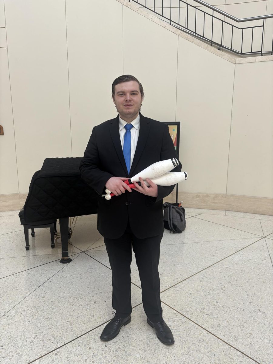 Bergen Whitney with his juggling batons in the Holland Terrell Library Atrium. 