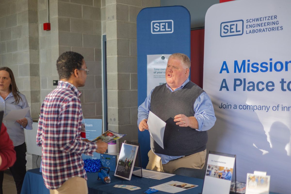 Company representatives talking to attendees at WSU's Spring Career Expo at Beasley Coliseum, Feb. 10, 2026.