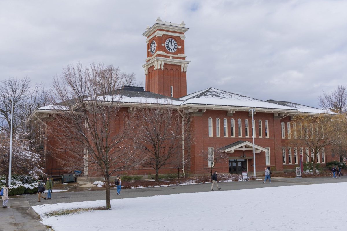 Students passing Bryan Hall on the snowy WSU Pullman campus, Feb. 17, 2026.
