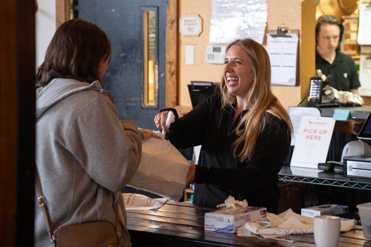 Manager Samantha Holt hands out a free meal during a "Feeding our Friends" event at Scusi Italian Restaurant in downtown Pullman on Tuesday, Apr. 14. 