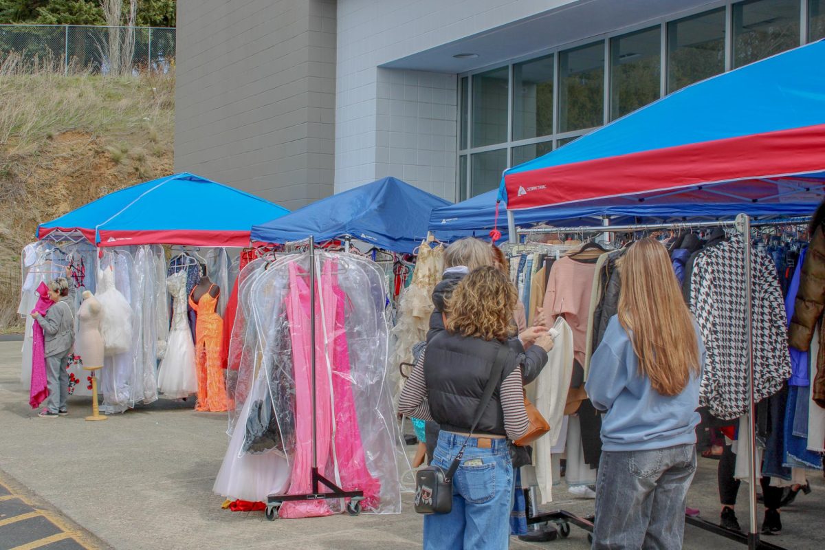Customer browsing the racks at Lily Bee's Boutique's closing sale, April 18, 2026.
