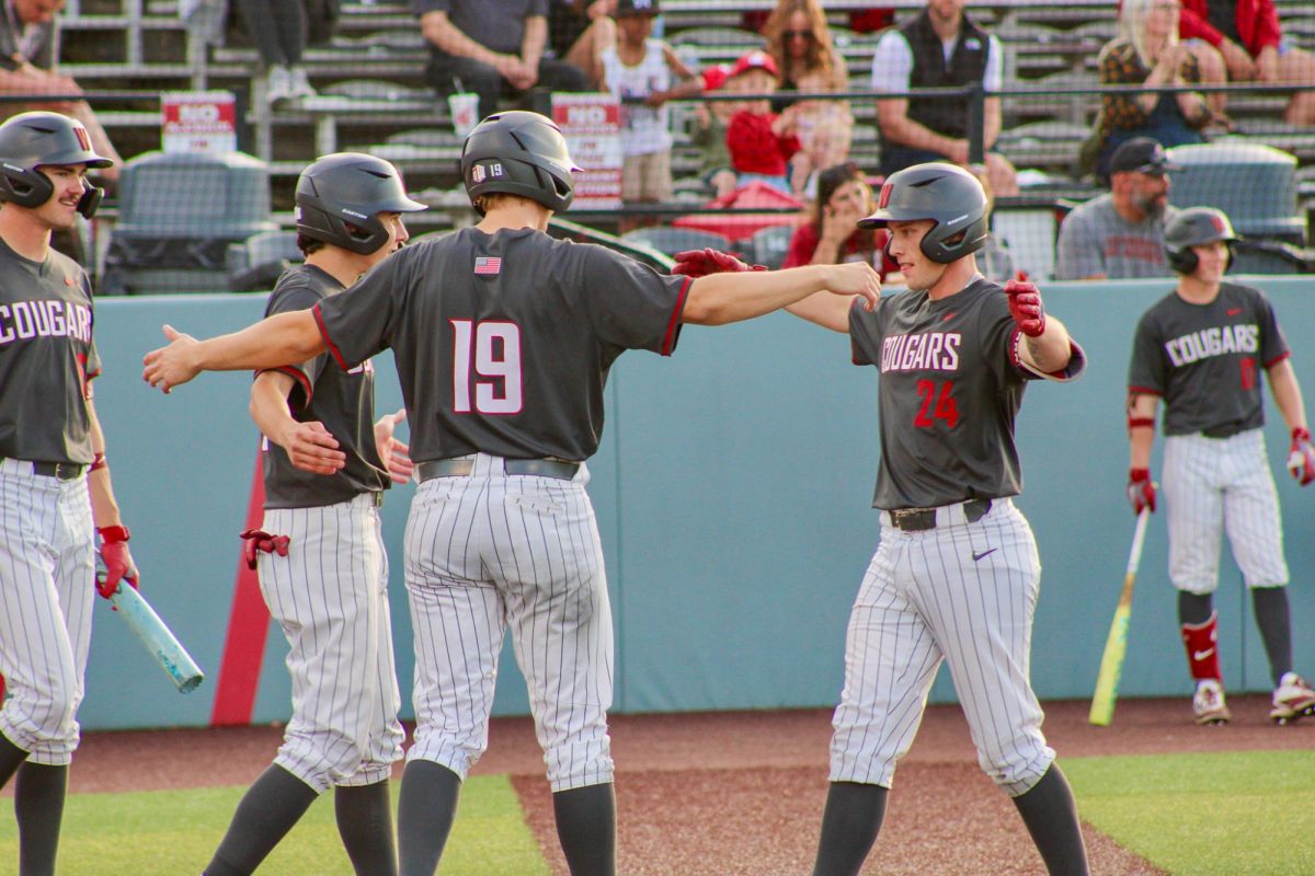 WSU Catcher Cam Macleod (24) brings it in for a hug with his teammates after scoring a run against Fresno State University baseball, May 2, 2026.
